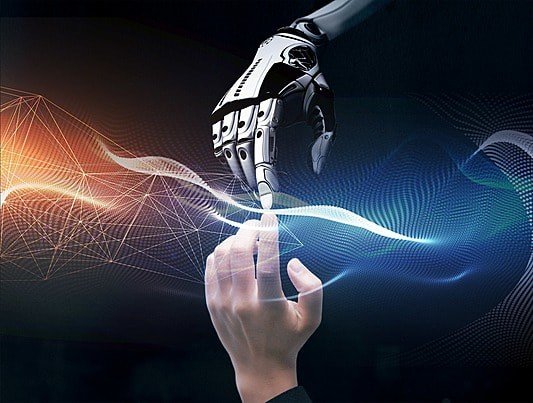Human hand reaching toward a robotic hand through flowing light